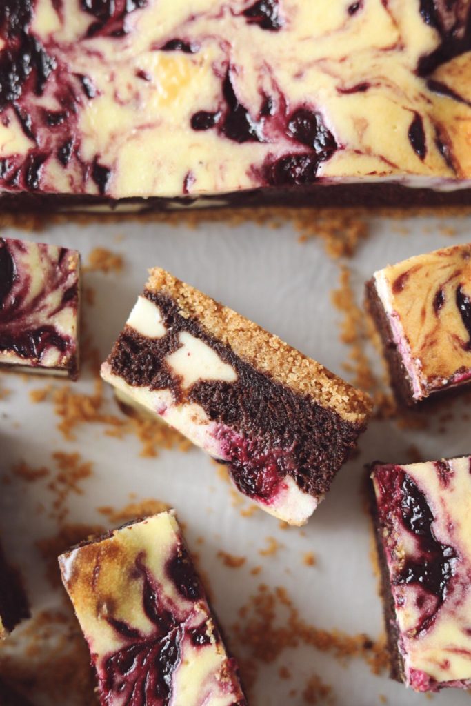 Cheesecake bars med brownie og brombær swirl